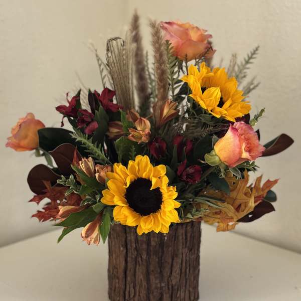 Sunflower and rose arrangement in a rustic wood container
