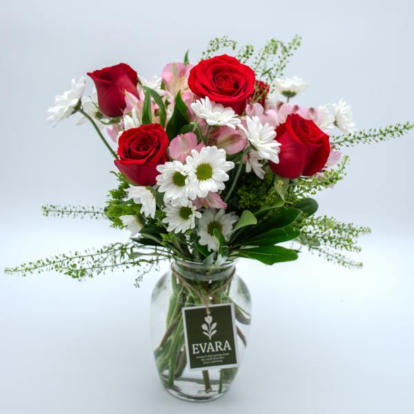 Red roses and white daisies in a glass vase