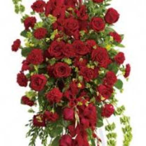 Tall standing spray of red roses and carnations on a white easel