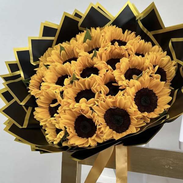 Bouquet of sunflowers wrapped in black and gold paper