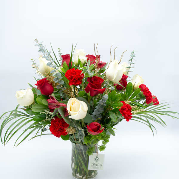 Red and white roses arranged in a clear glass vase