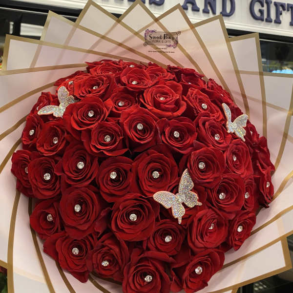 Large bouquet of red roses with rhinestone accents and butterfly decorations