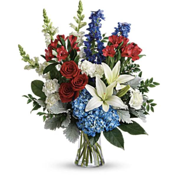 Bouquet of red, white, and blue flowers in a clear glass vase