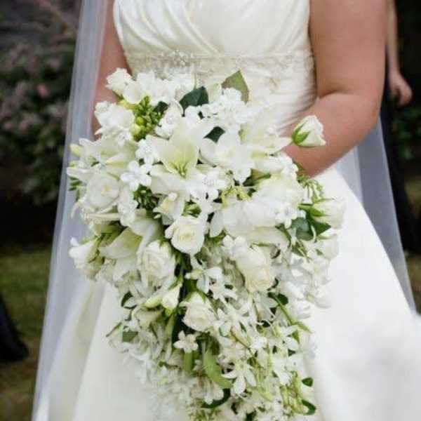 Bride holding a cascading white wedding bouquet