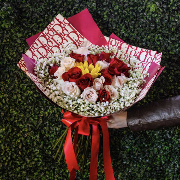 Bouquet of red and blush roses with yellow flowers and baby's breath