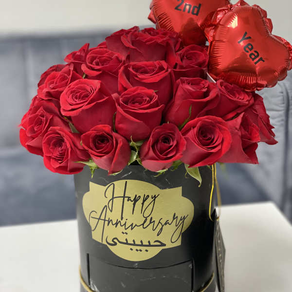 Red roses in a black box with two heart balloons