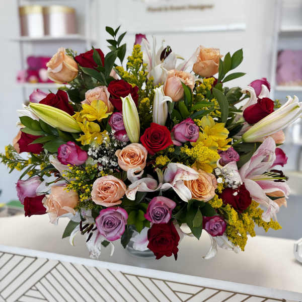 Mixed bouquet of roses and lilies in a glass vase