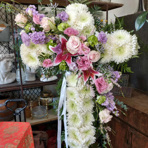 Large cross-shaped floral tribute with white chrysanthemums and pink roses