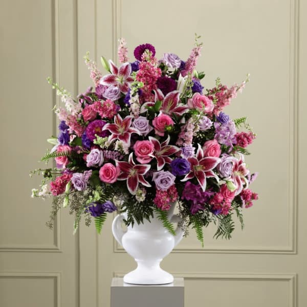 Large bouquet of pink, purple, and white flowers in a white vase