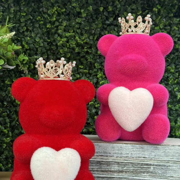 Two plush teddy bears with crowns and heart patches, one red and one pink
