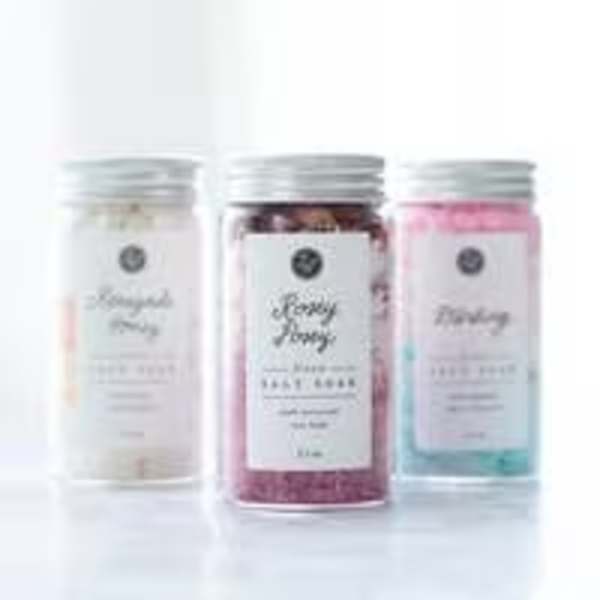 Three labeled jars of bath salts in pastel colors