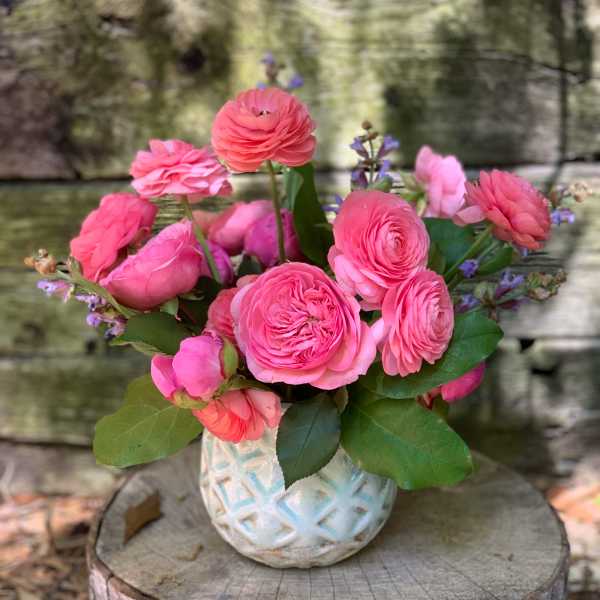 Pink ranunculus bouquet in a white textured vase