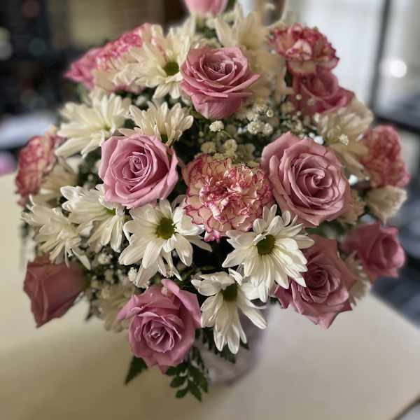 Bouquet of pink roses and white daisies with a pink carnation