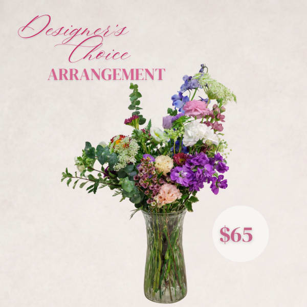 Mixed flower arrangement in a clear glass vase with pink and purple blooms