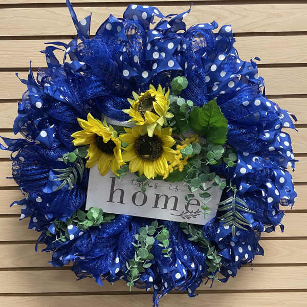 Blue polka-dot wreath with sunflowers and a "this is home" sign