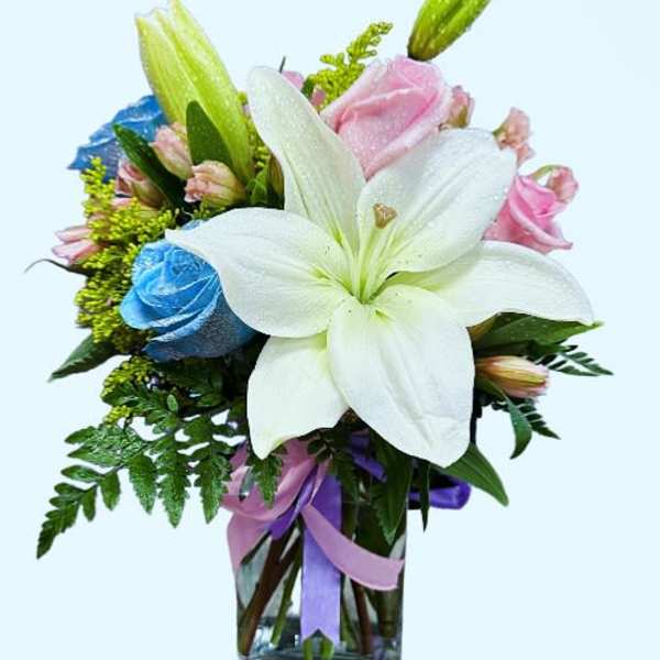 Bouquet of white lilies and pink roses in a glass vase with ribbon