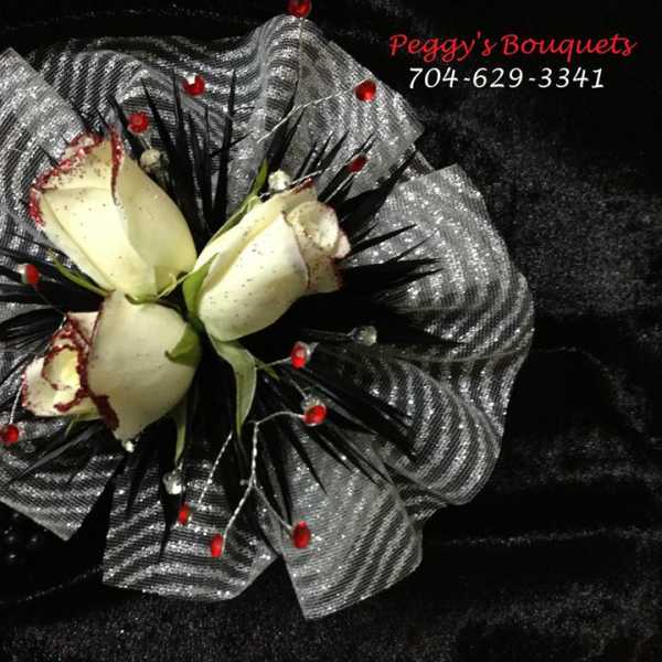 White rose bouquet with silver mesh wrap and red accents
