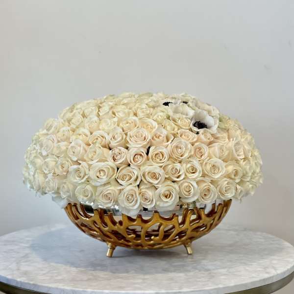 Cream rose arrangement in a gold decorative bowl