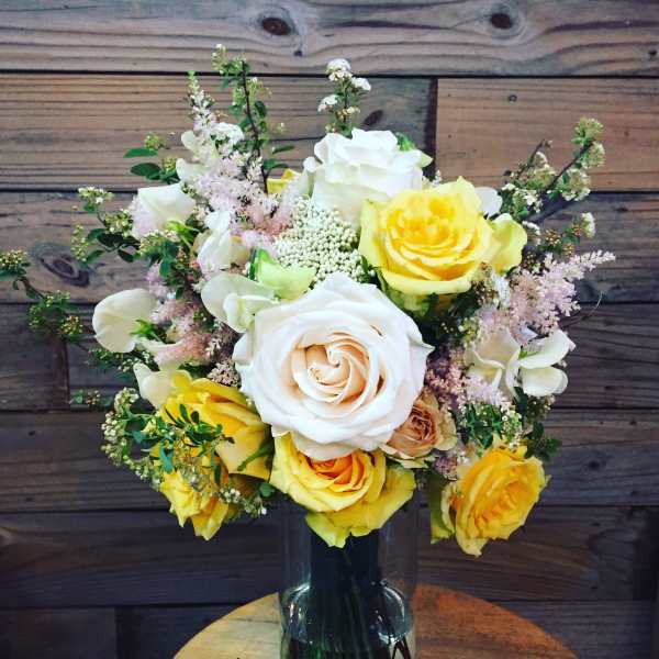 Bouquet of yellow and white roses in a glass vase