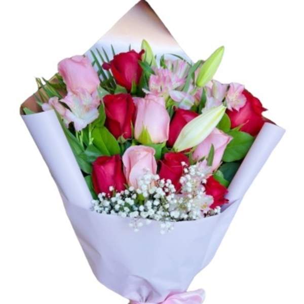 Bouquet of pink and red roses with lilies wrapped in pale lavender paper