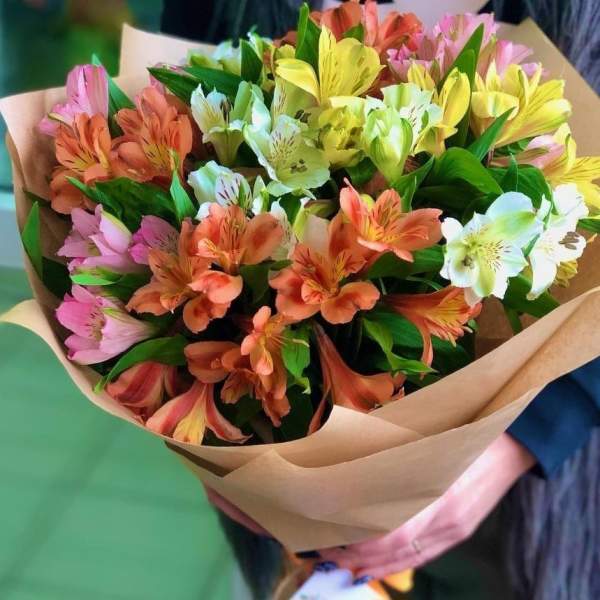 Bouquet of multicolored alstroemeria flowers wrapped in brown paper