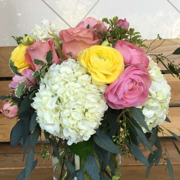 Pink and yellow flower arrangement in a glass vase