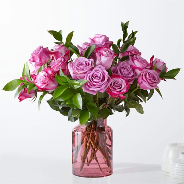 Pink roses arranged in a pink glass vase