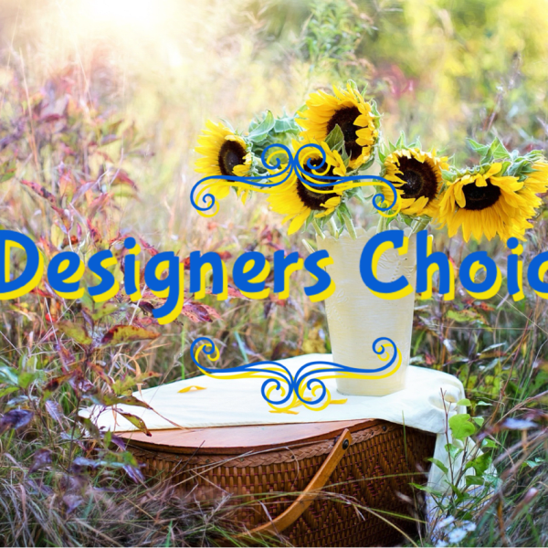 Sunflowers in a white vase on a picnic basket with "Designers Choice" text overlay