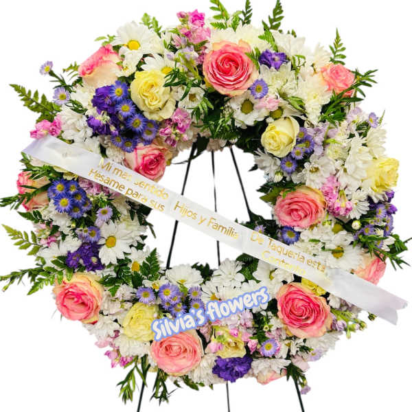 Heart-shaped floral wreath with pink roses, white daisies, and purple flowers