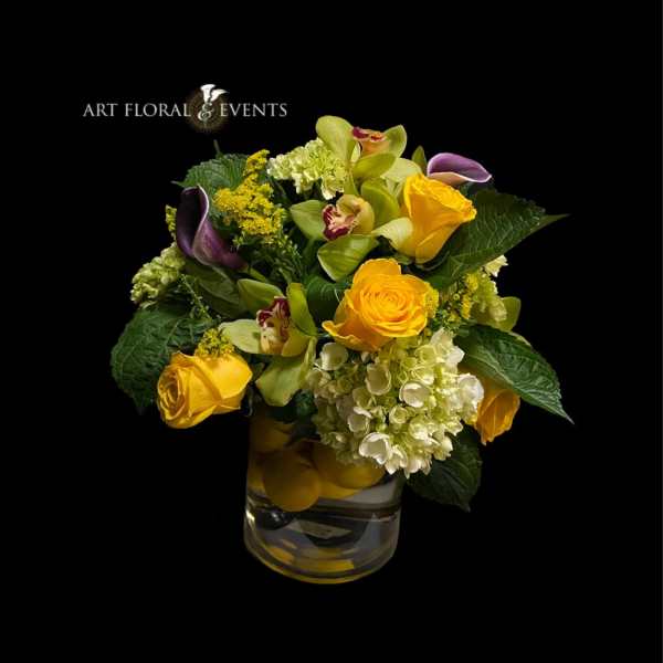 Yellow roses and orchids in a glass vase