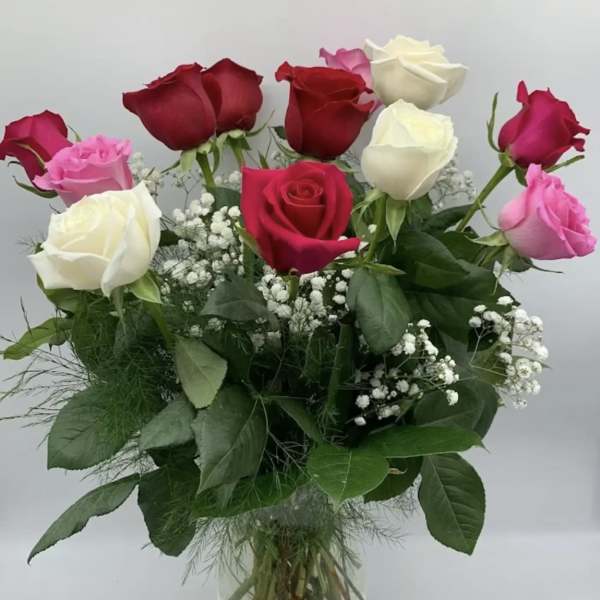 Bouquet of red, pink, and white roses in a clear glass vase