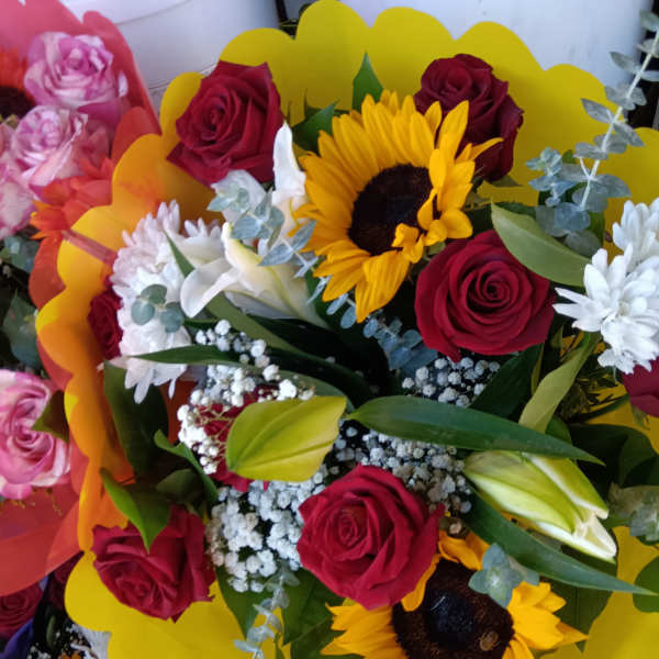 Bouquet of red roses and sunflowers with white accent flowers