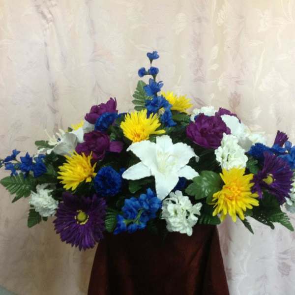 Colorful floral arrangement with white lilies, yellow daisies, and purple blooms