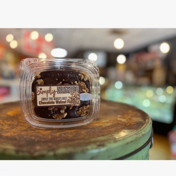 Container of chocolate walnut fudge on a table