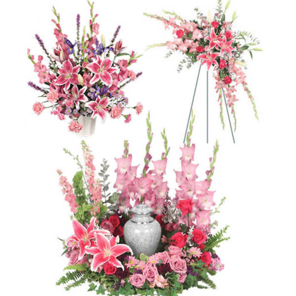Pink and red floral funeral arrangement with lilies and roses around a silver urn