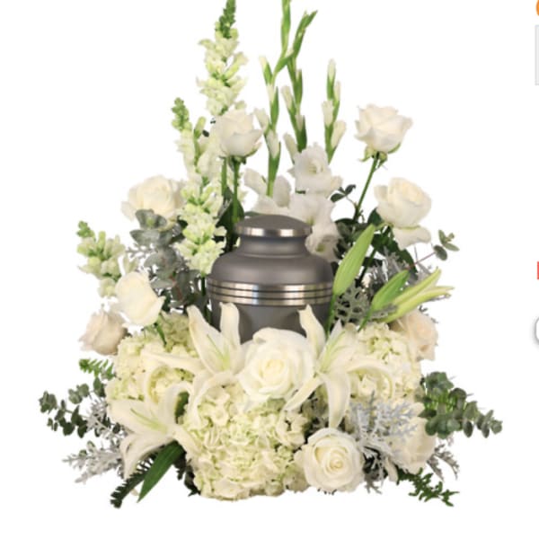 White floral funeral arrangement with a silver urn centerpiece
