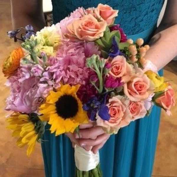 Colorful hand-tied bouquet with roses and a sunflower