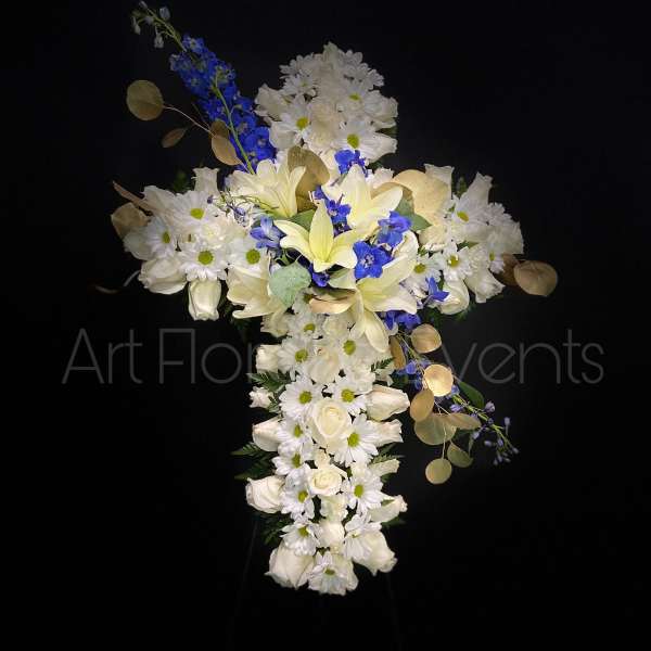 Cross-shaped floral arrangement with white flowers and blue accents