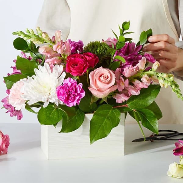 Pink and white mixed flower arrangement in a white box