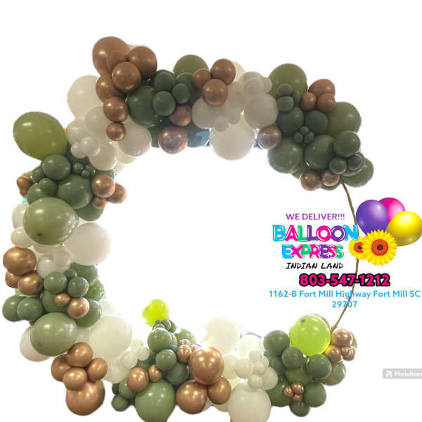 Balloon arch in green, white, and bronze tones