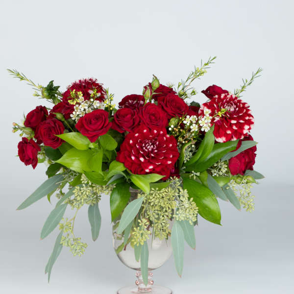 Red roses and red-white dahlias in a clear glass vase