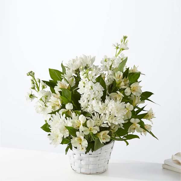 White floral arrangement in a white woven basket