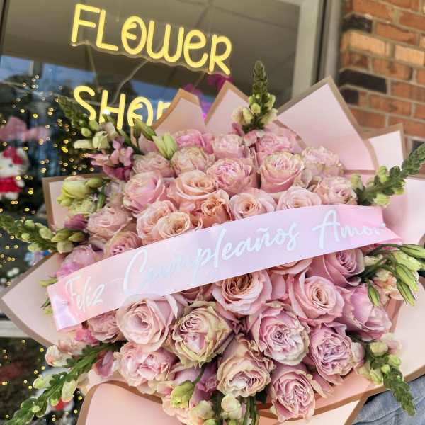 Large bouquet of pale pink roses wrapped in pink paper