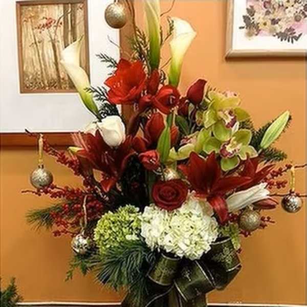 Tall red and white floral arrangement in a glass vase