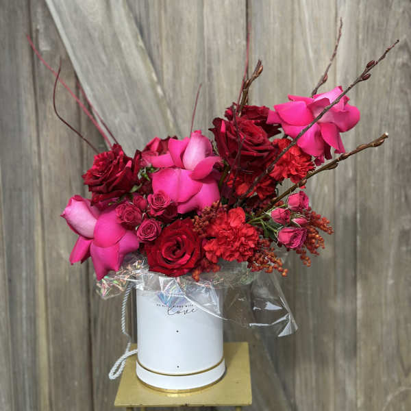 Pink and red rose bouquet in a white hatbox