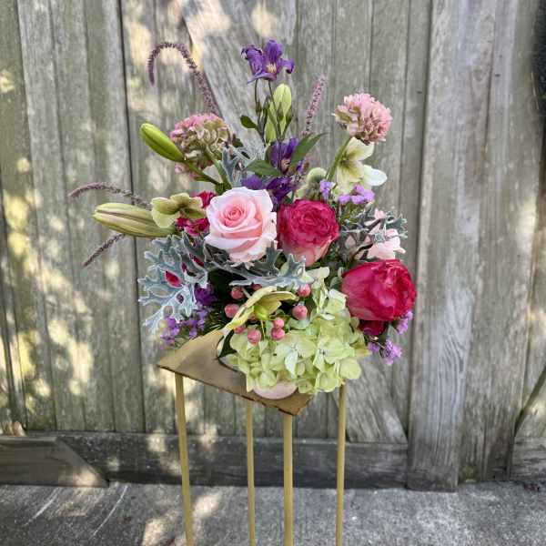 Mixed bouquet with pink roses, lilies, and purple blooms in a vase