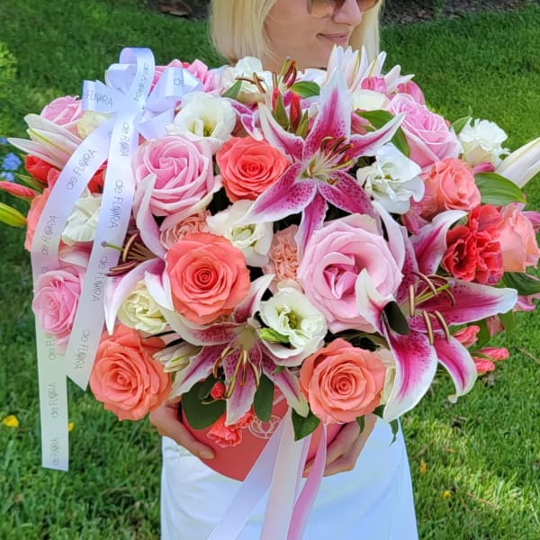 Large bouquet of pink roses and lilies with ribbon in a box