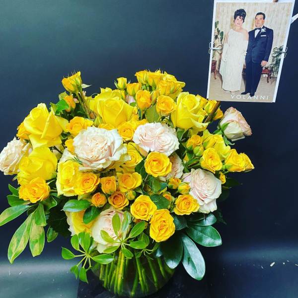 Bouquet of yellow and pale pink roses in a glass vase