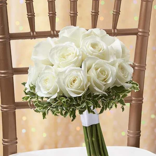 White rose bouquet with variegated greenery on a chair