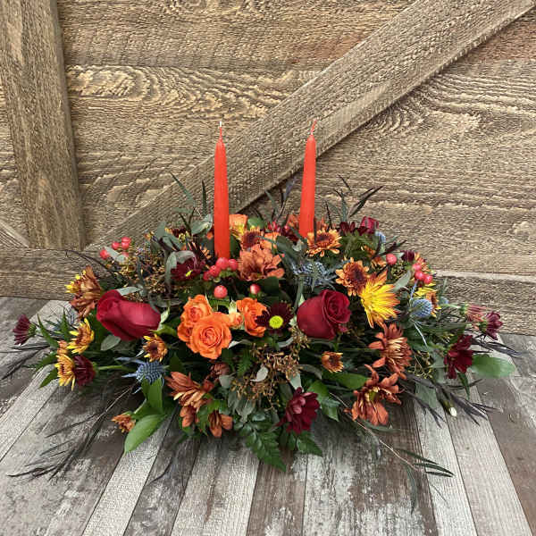Autumn floral centerpiece with red candles and mixed blooms